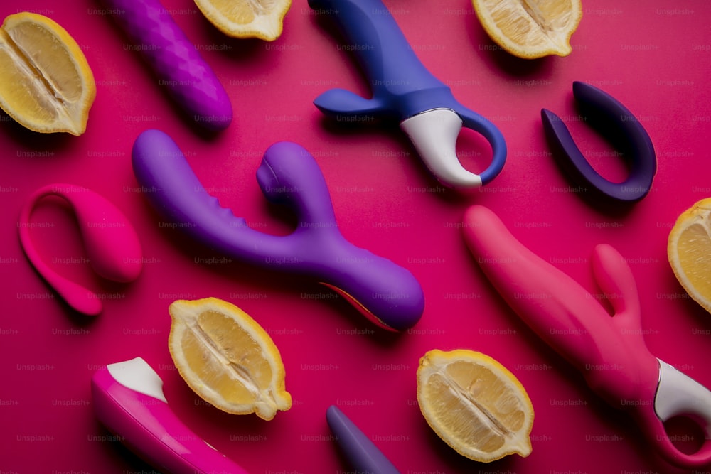a group of scissors and lemon slices on a pink surface