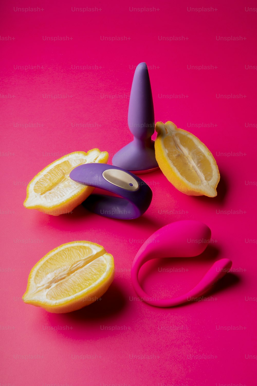 a pair of scissors and a sliced orange on a pink background