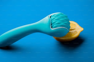 uma escova de dentes azul sentada em cima de uma fatia laranja