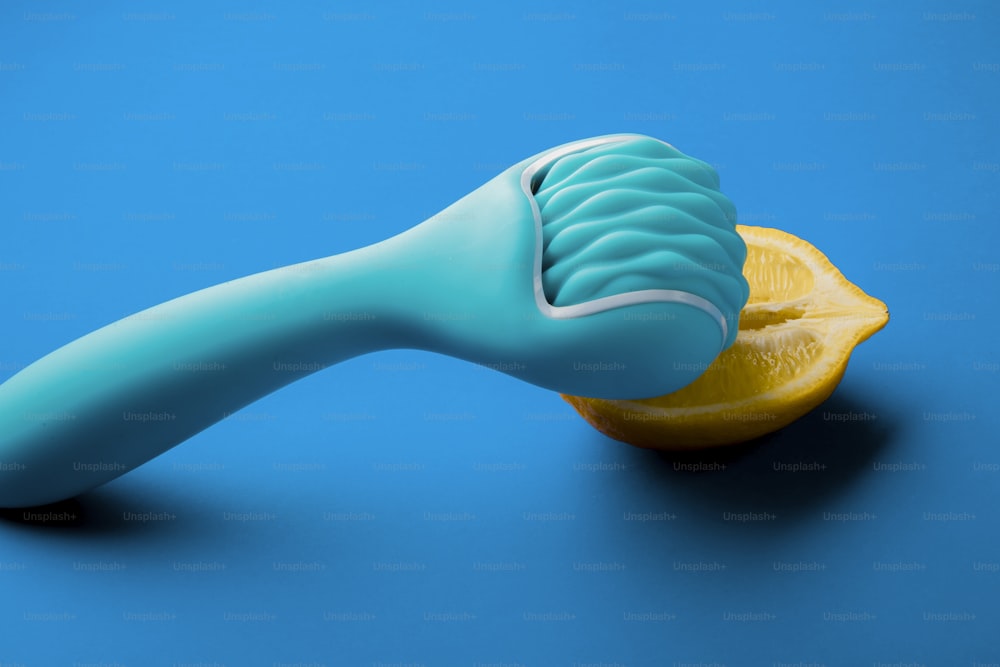 uma escova de dentes azul sentada em cima de uma fatia laranja