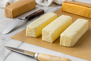 three pieces of cheese sitting on top of a cutting board