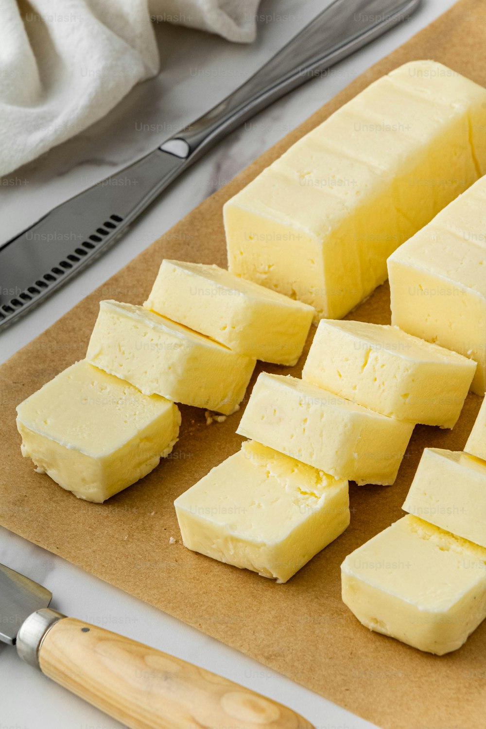 a cutting board topped with cubes of butter next to a knife