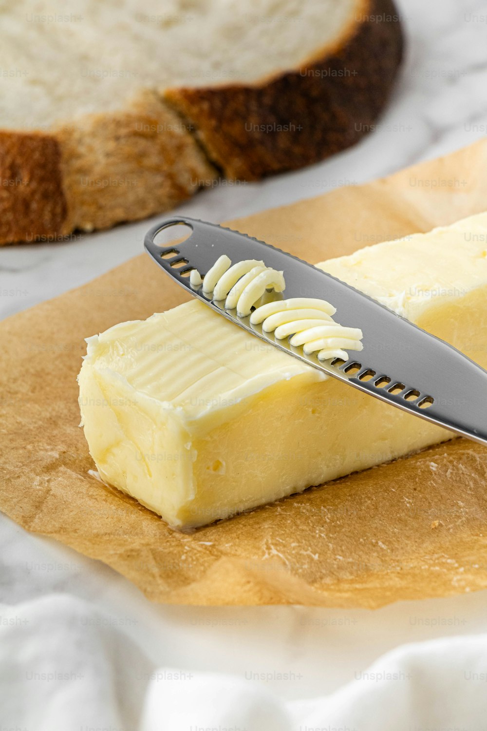 a piece of butter and a knife on a cutting board