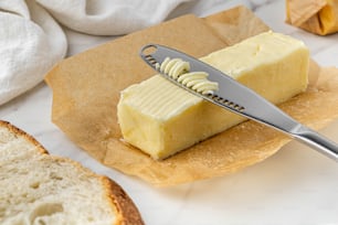 un trozo de mantequilla encima de un trozo de pan