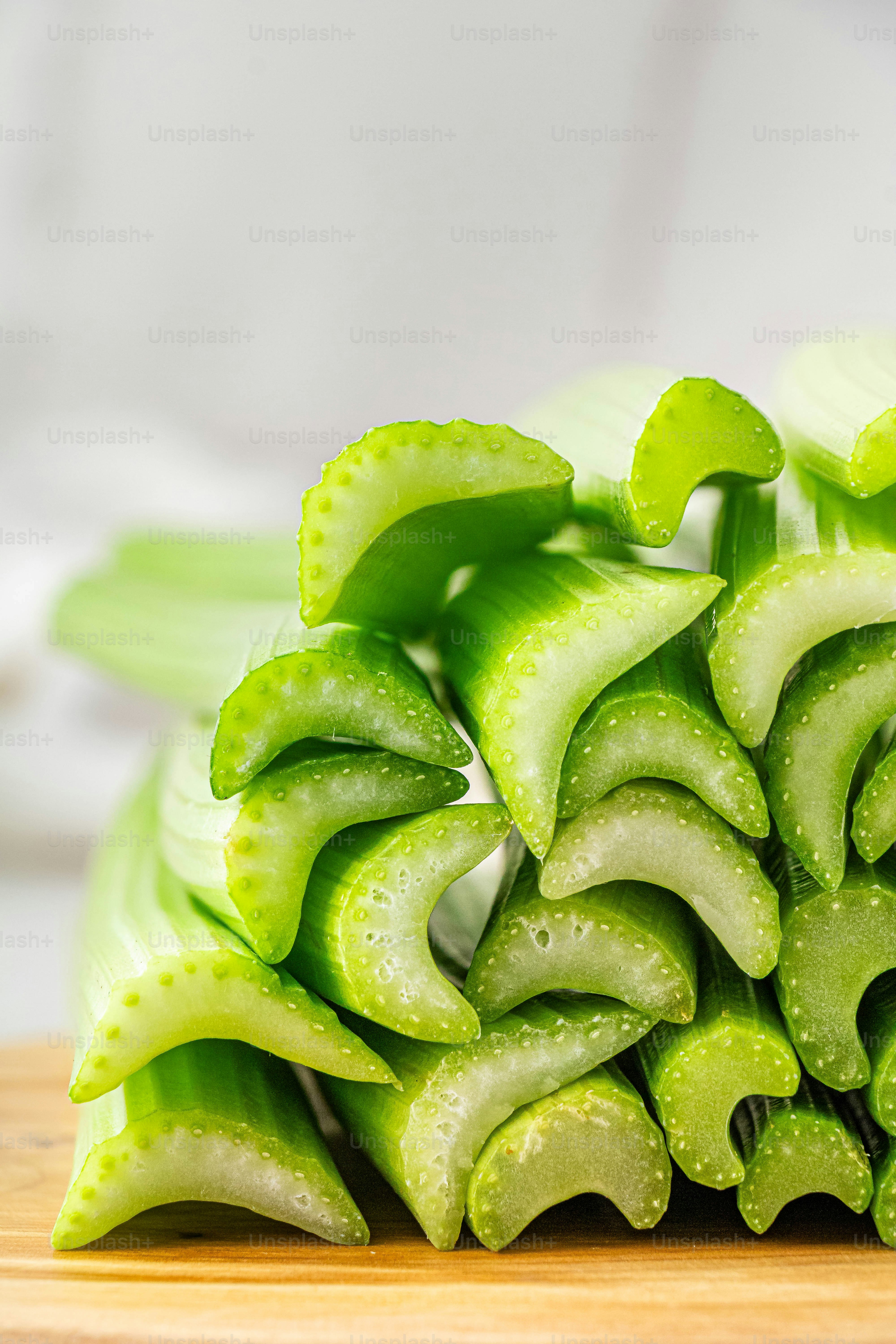 a pile of sliced green vegetables sitting on top of a wooden cutting board