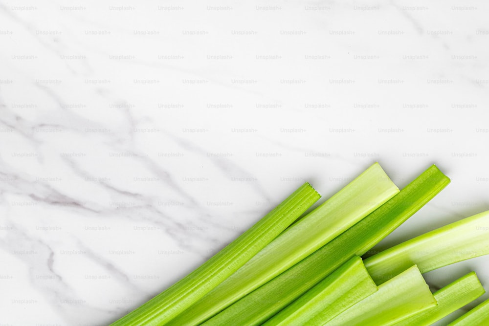 a pile of celery sitting on top of a white counter