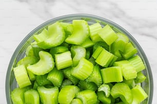 a glass bowl filled with sliced up celery