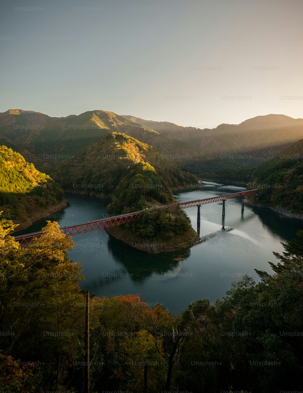 a bridge over a river surrounded by mountains