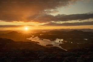 the sun is setting over a mountain range