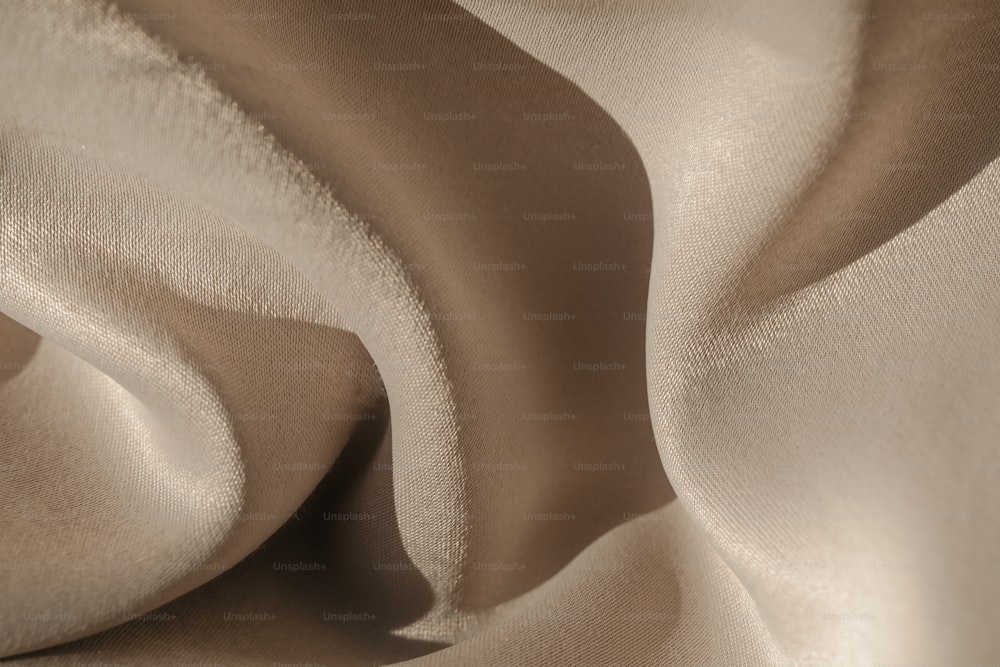 Eine Nahaufnahme eines beigefarbenen Stoffes mit einem Wellenmuster