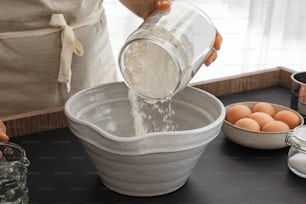 una persona che versa acqua in una ciotola di uova
