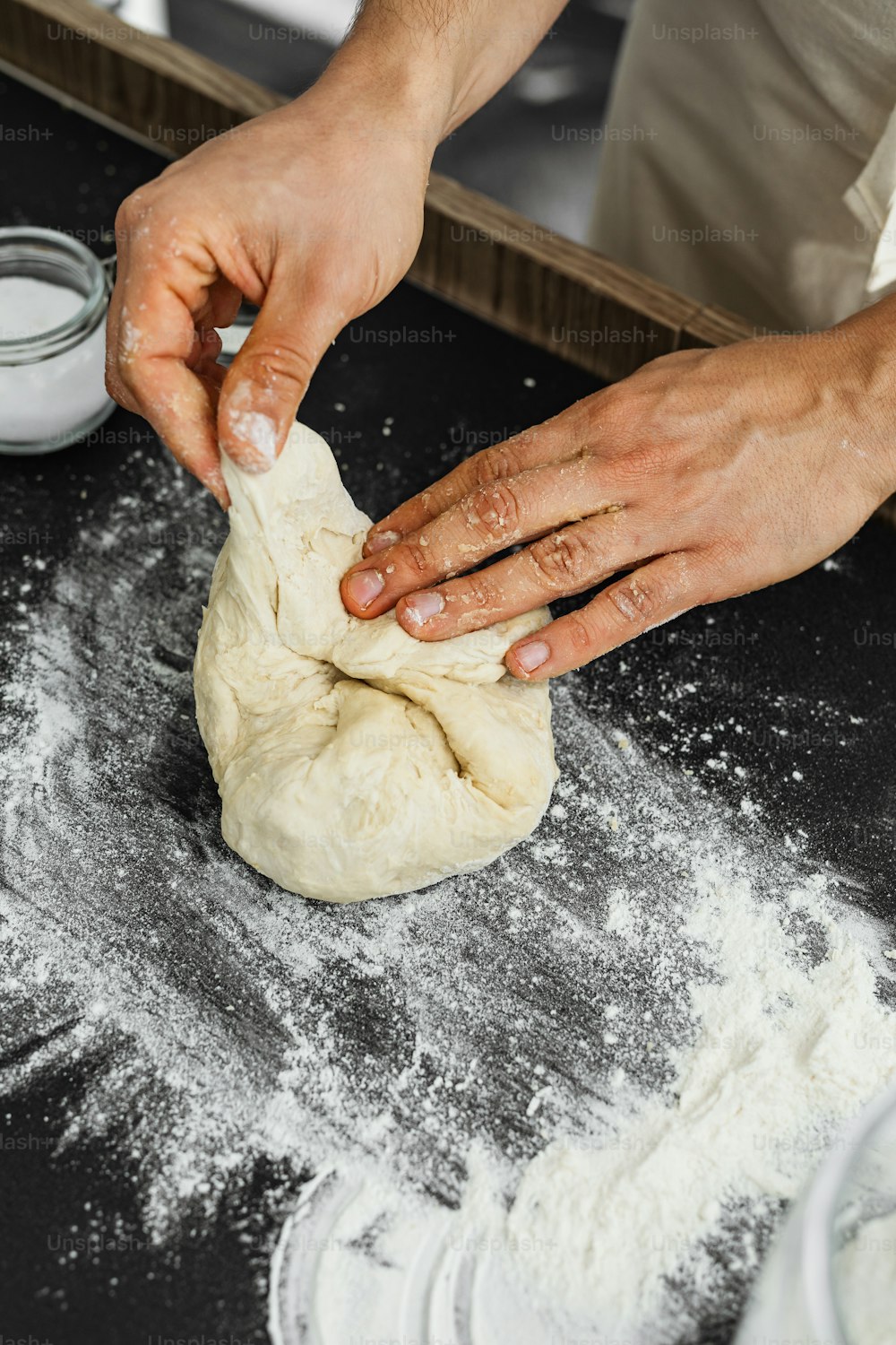 a person kneading dough on top of a table