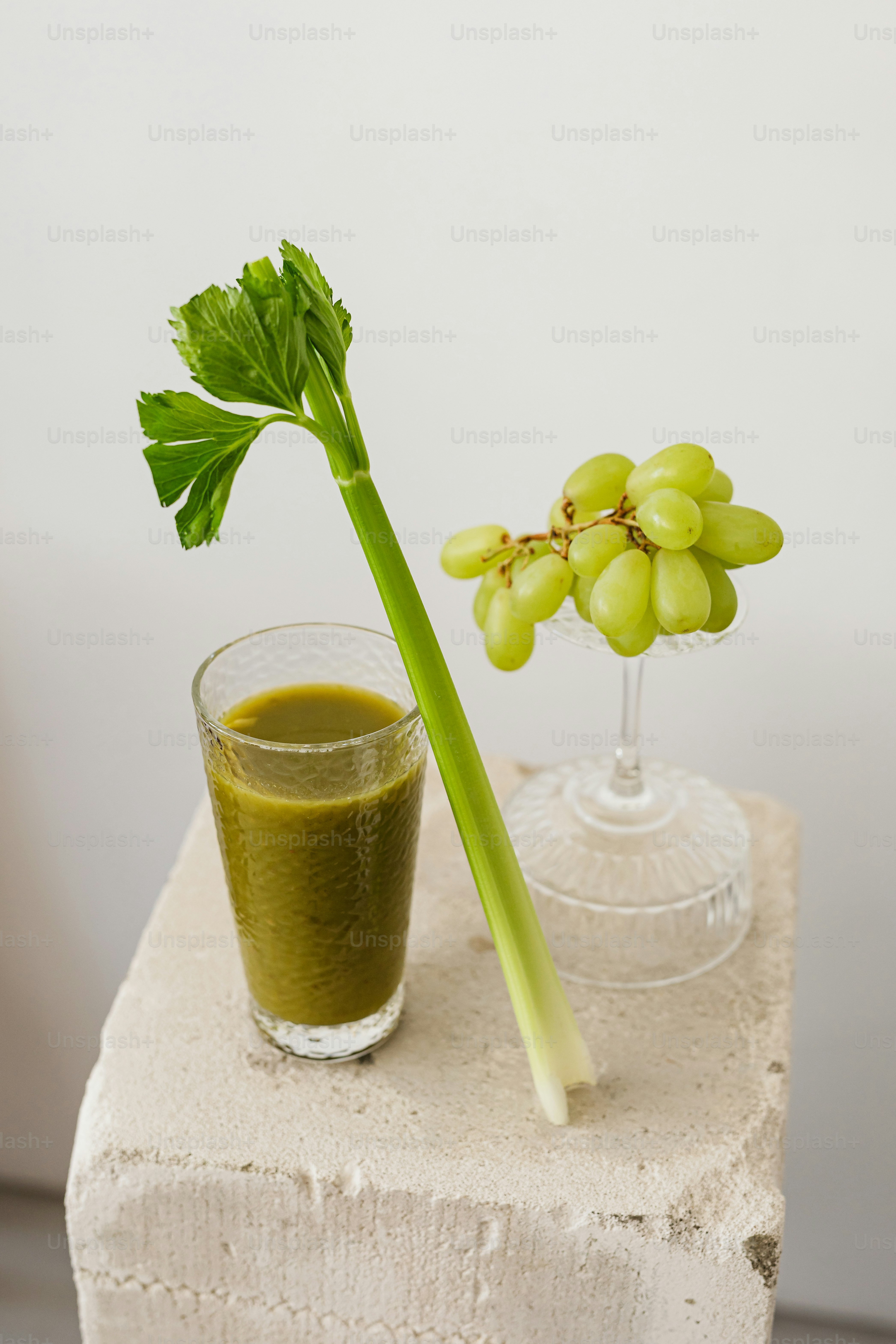 A glass of green juice next to a stem of grapes photo – Food Image on ...