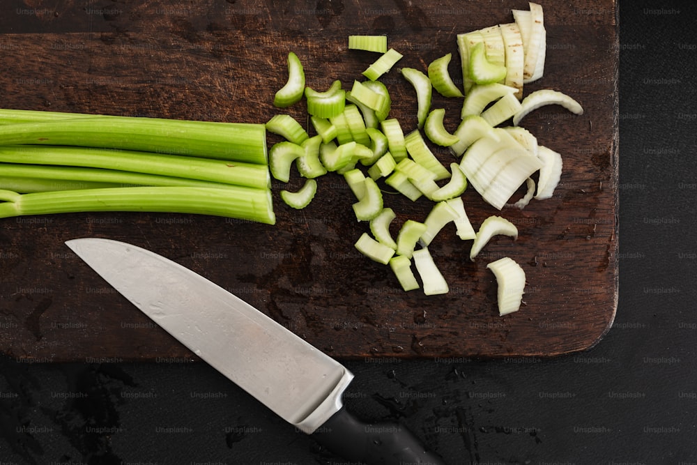 a cutting board with a knife and chopped celery