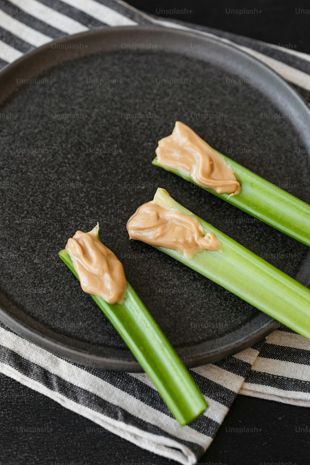 celery sticks with peanut butter on them on a plate