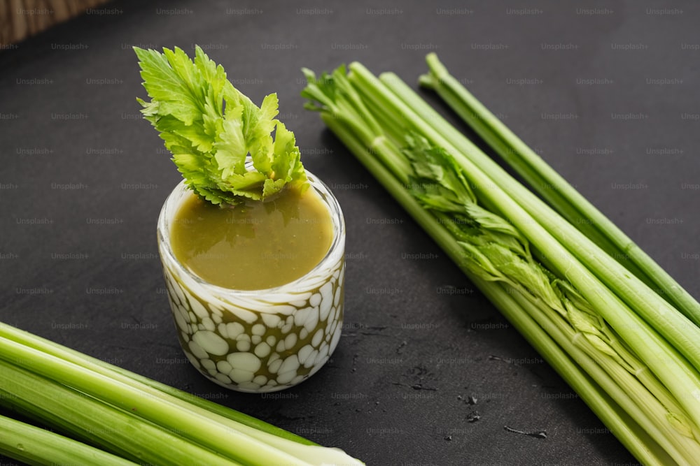 celery sticks and a small cup of sauce on a table