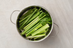 a pot filled with celery on top of a table