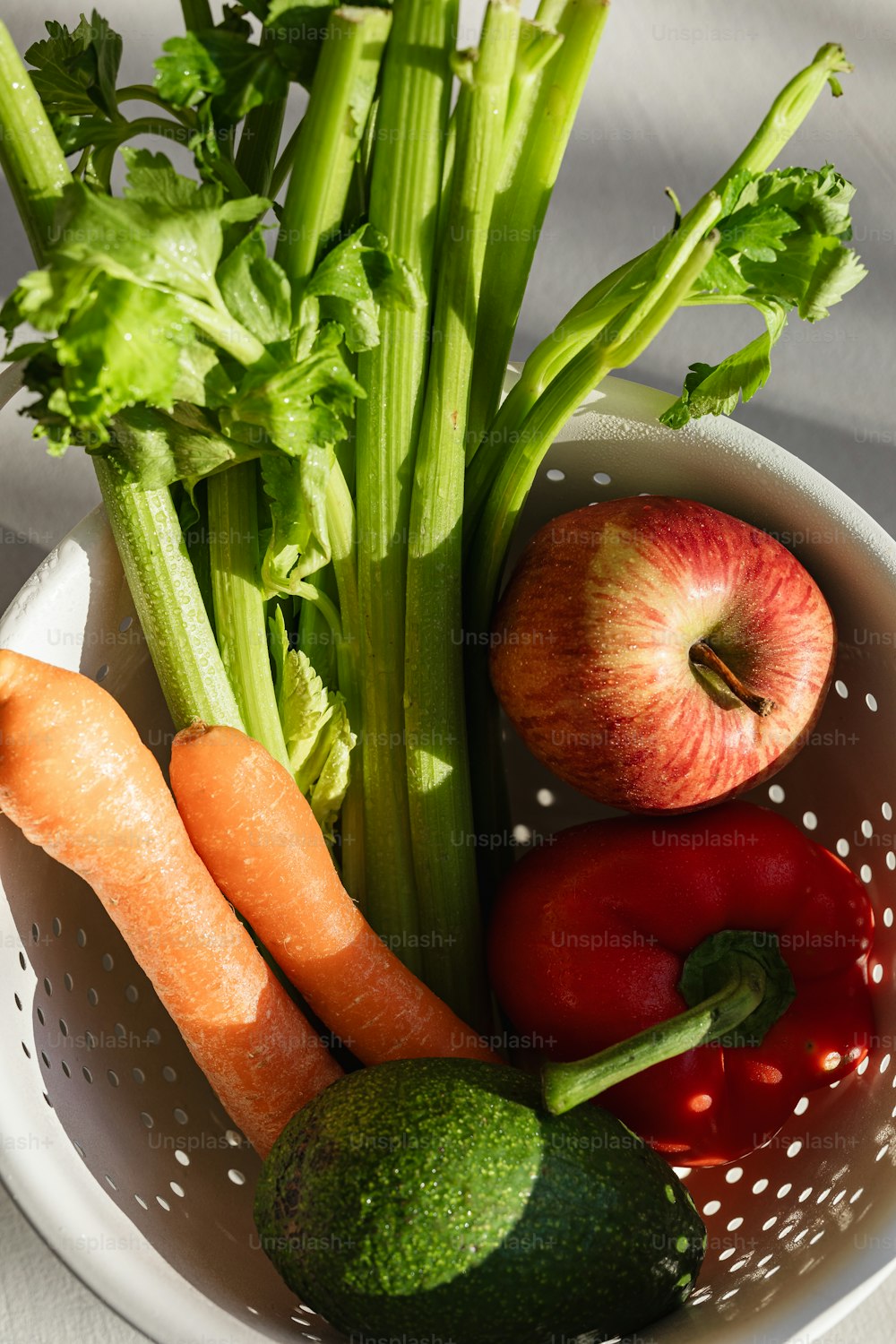 a white bowl filled with vegetables and fruits