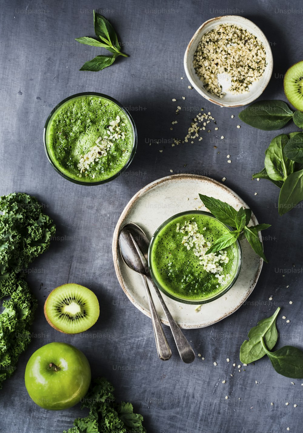 a table topped with bowls of green smoothies