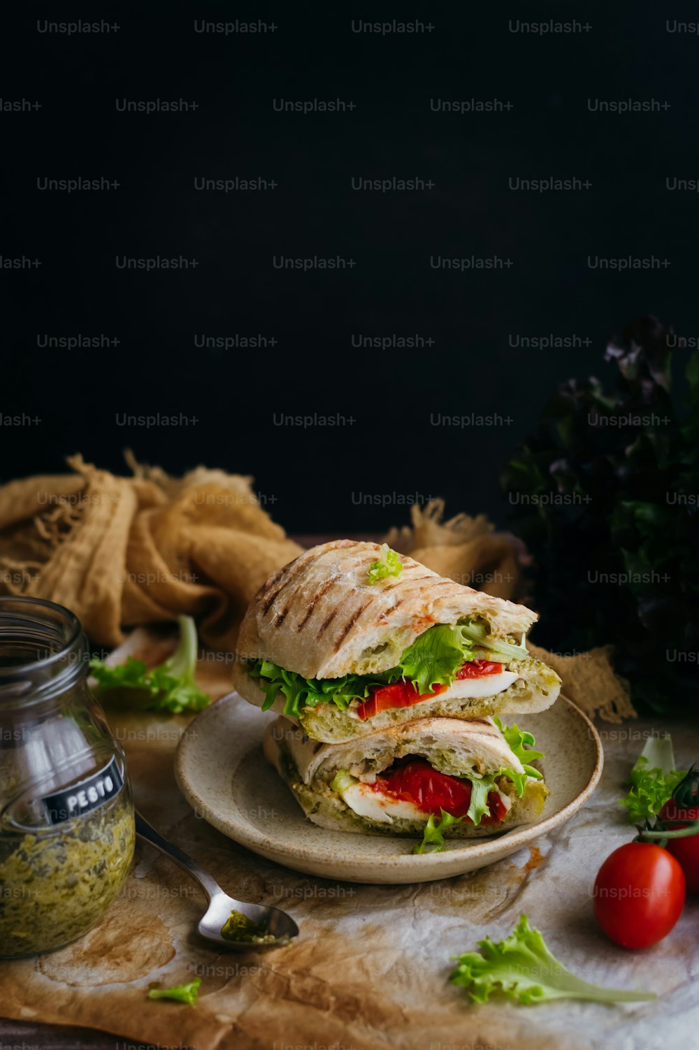 a sandwich with lettuce and tomatoes on a plate