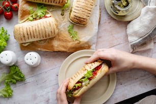 a person is holding a sandwich on a plate