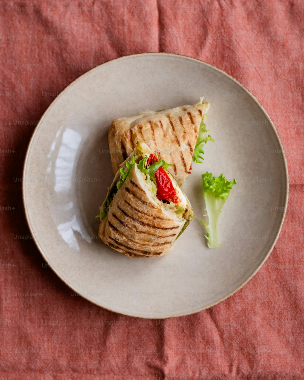 a white plate topped with a cut in half sandwich