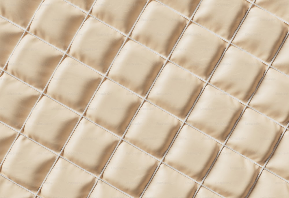 a close up view of a beige tile wall