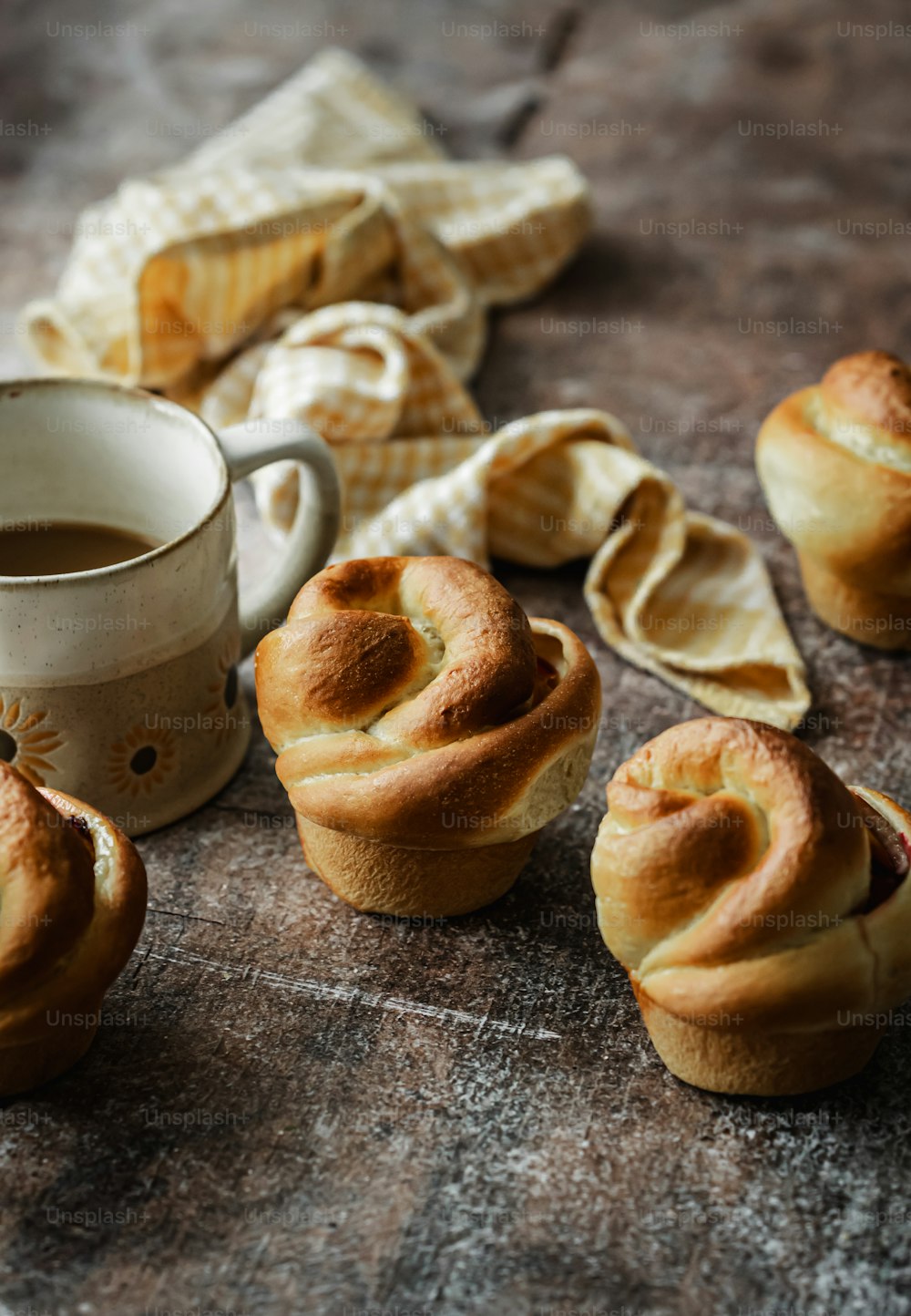 a table topped with rolls and a cup of coffee