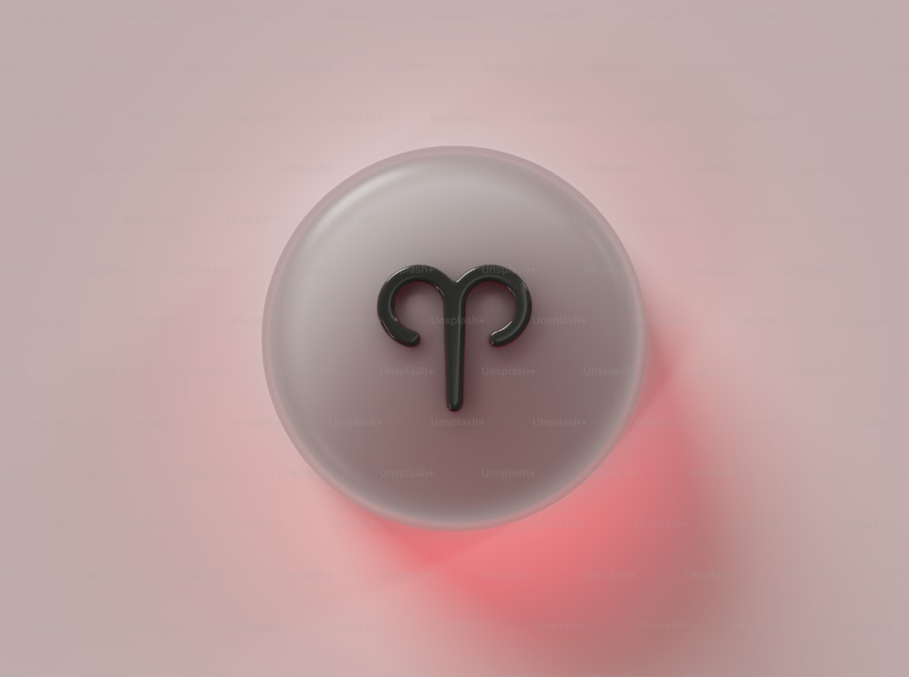 um botão branco com um signo do zodíaco preto nele