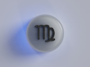 a white button with a black zodiac sign on it