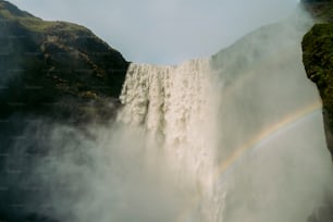 ein Wasserfall mit einem Regenbogen in der Mitte