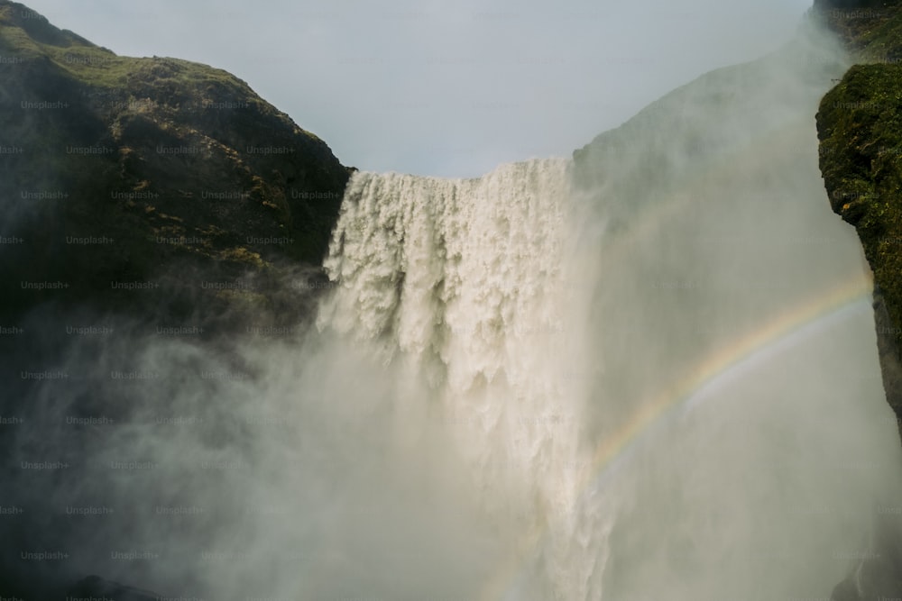 a waterfall with a rainbow in the middle of it