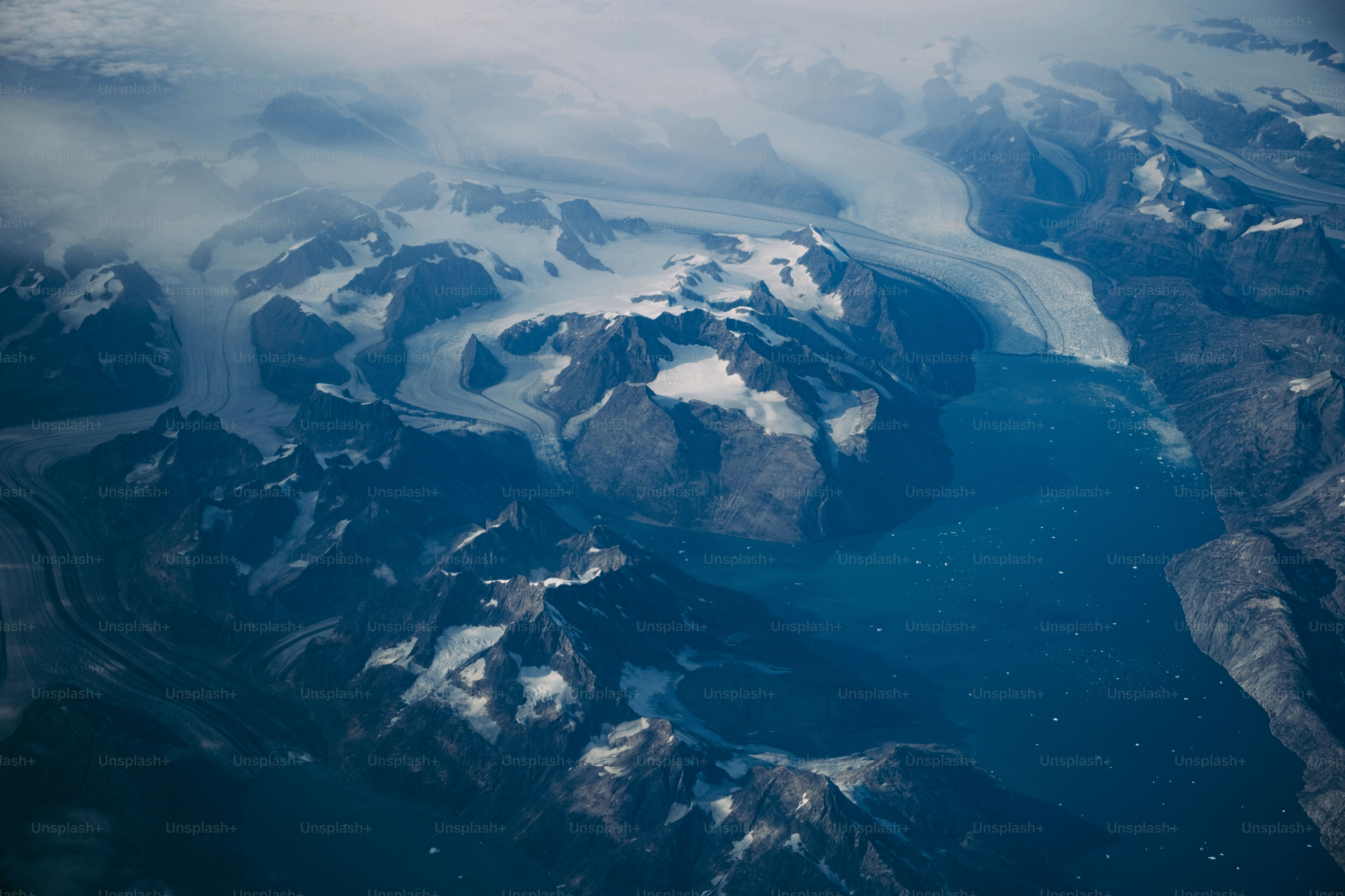 An aerial view of snow covered mountains and rivers photo – Travel ...
