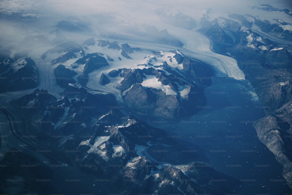 an aerial view of snow covered mountains and rivers