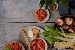 a table topped with plates of food and chopsticks