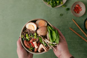 a person holding a bowl of food on a table