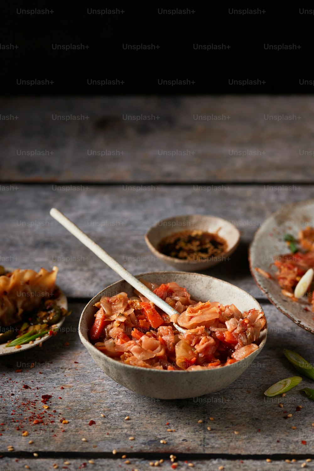 a wooden table topped with bowls of food