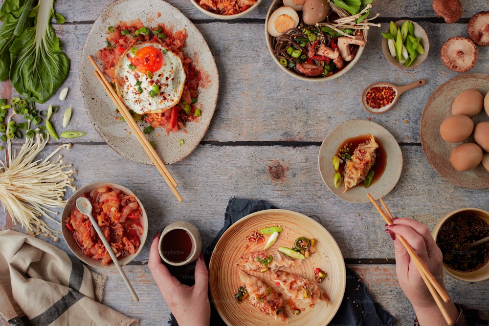 a table topped with plates of food and chopsticks