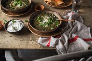 una mesa cubierta con tazones de sopa y un tazón de crema agria