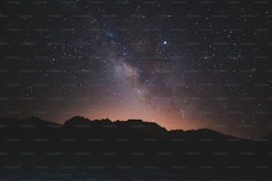 el cielo nocturno con estrellas sobre una cadena montañosa