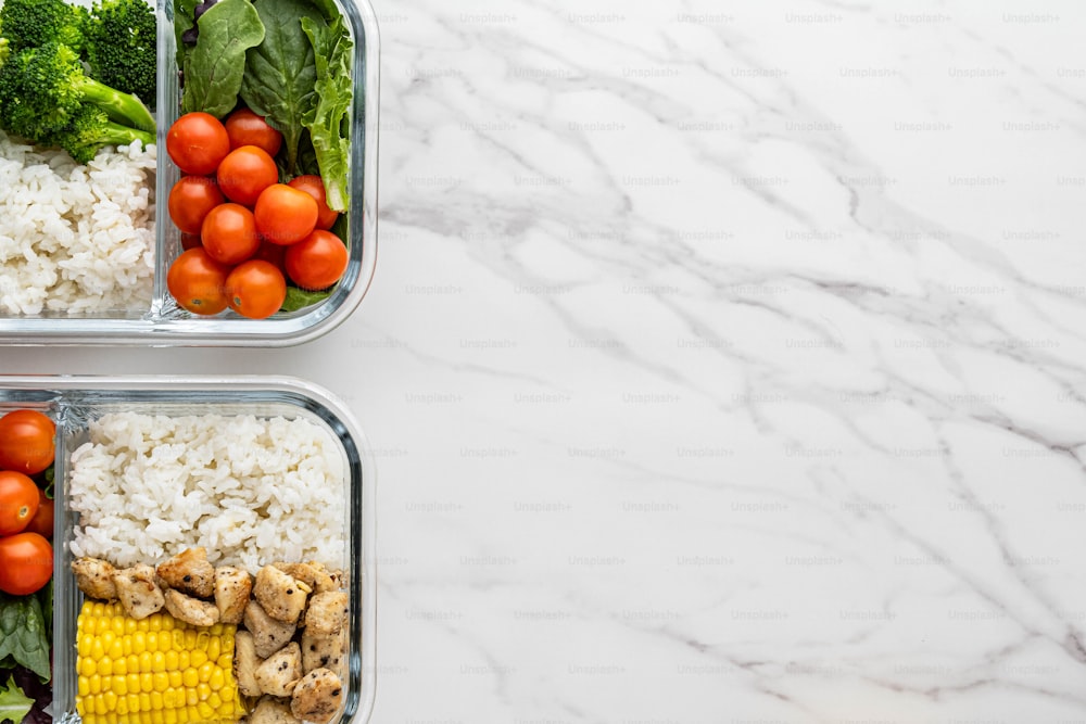 two plastic containers filled with vegetables and rice