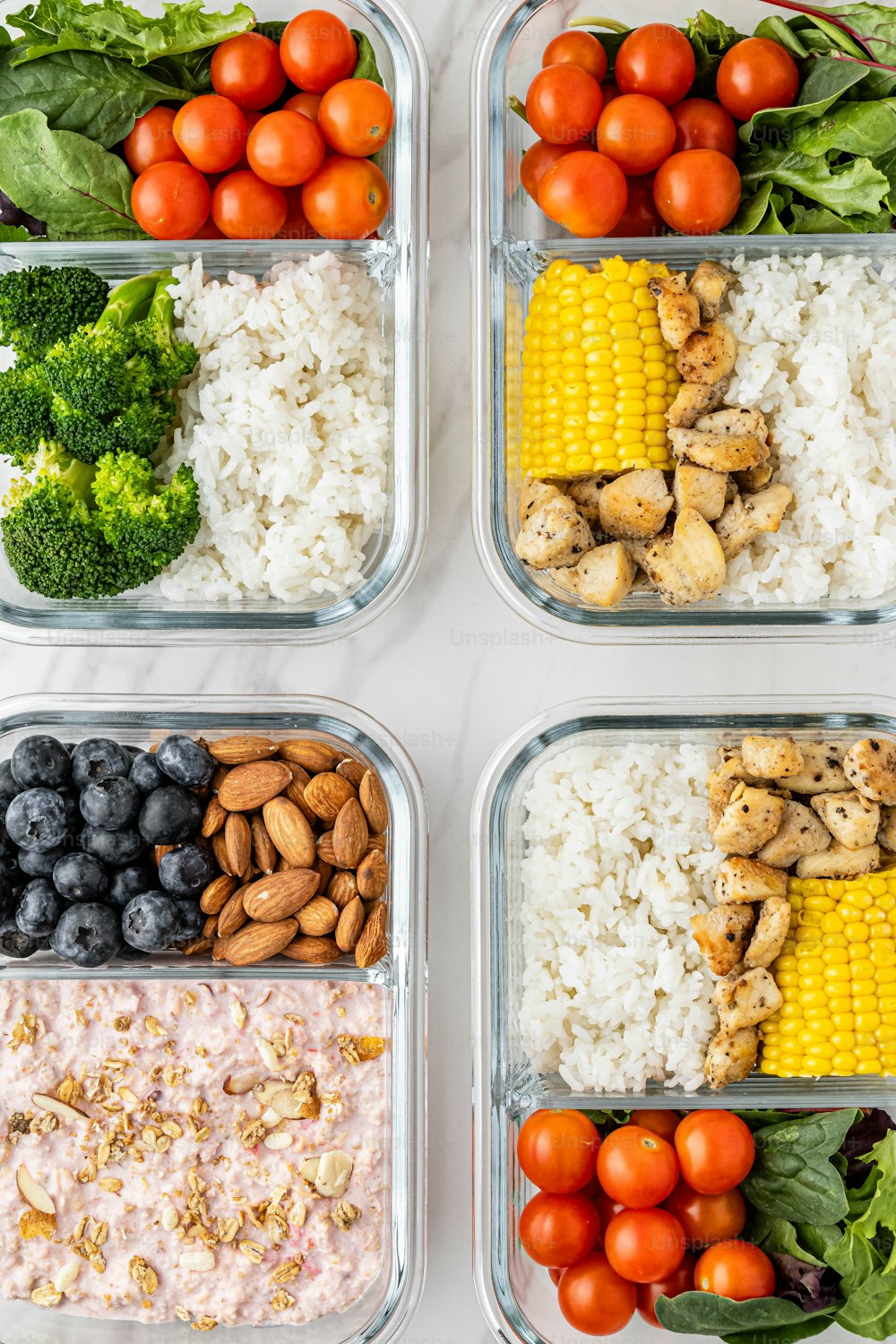 four plastic containers filled with different types of food