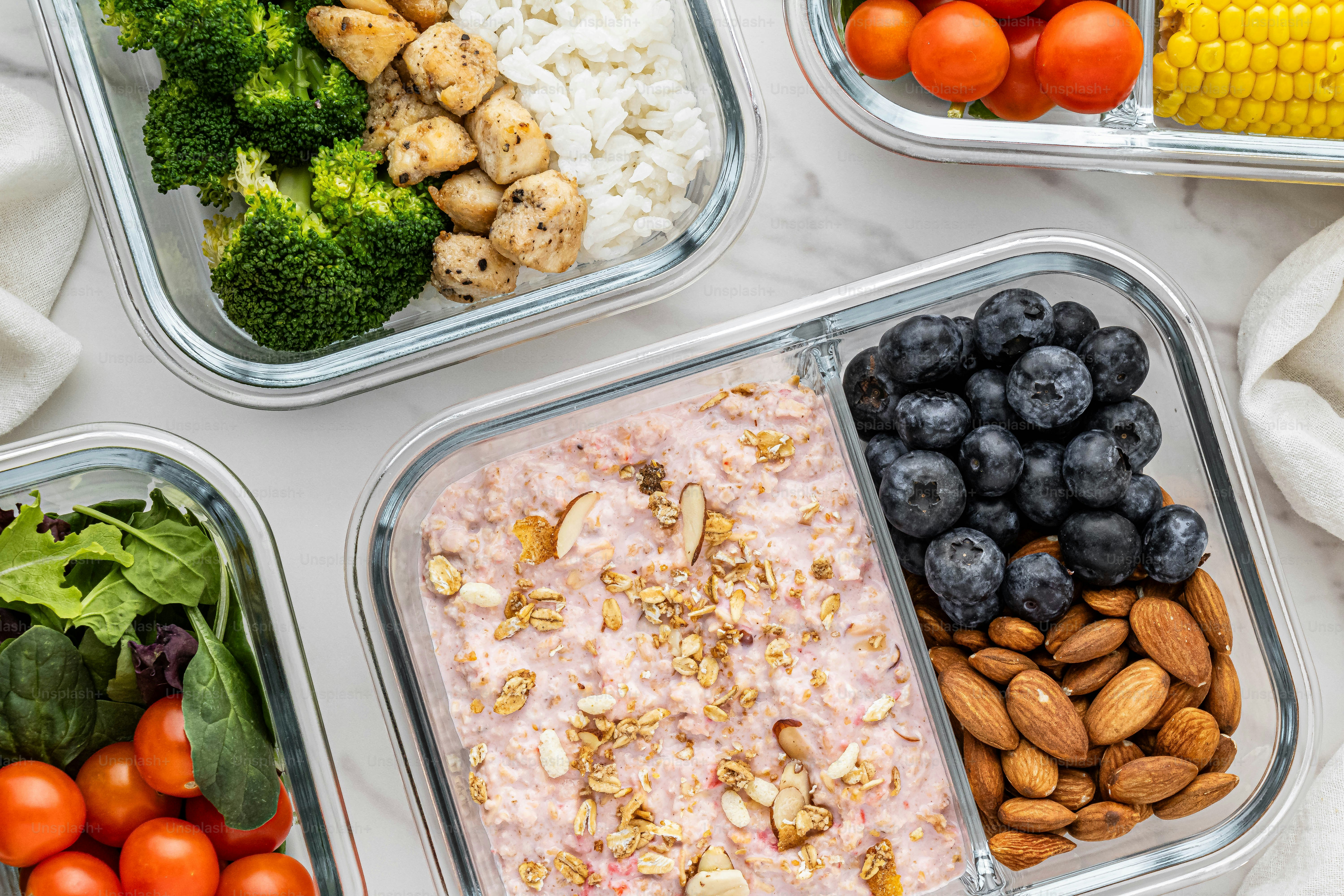 uma mesa coberta com recipientes cheios de diferentes tipos de alimentos