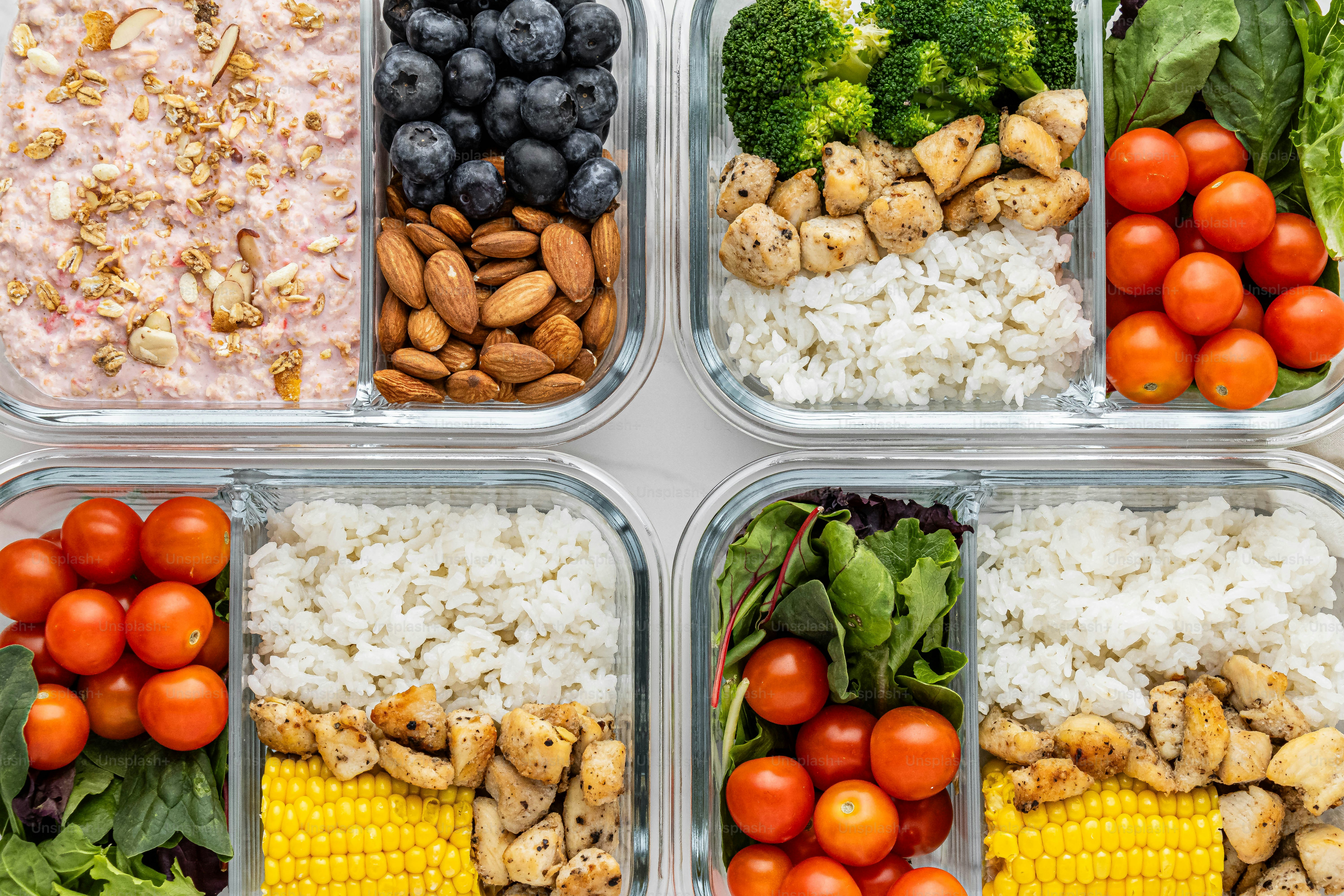 quatro recipientes plásticos cheios de diferentes tipos de alimentos