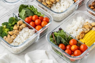 four plastic containers filled with different types of food