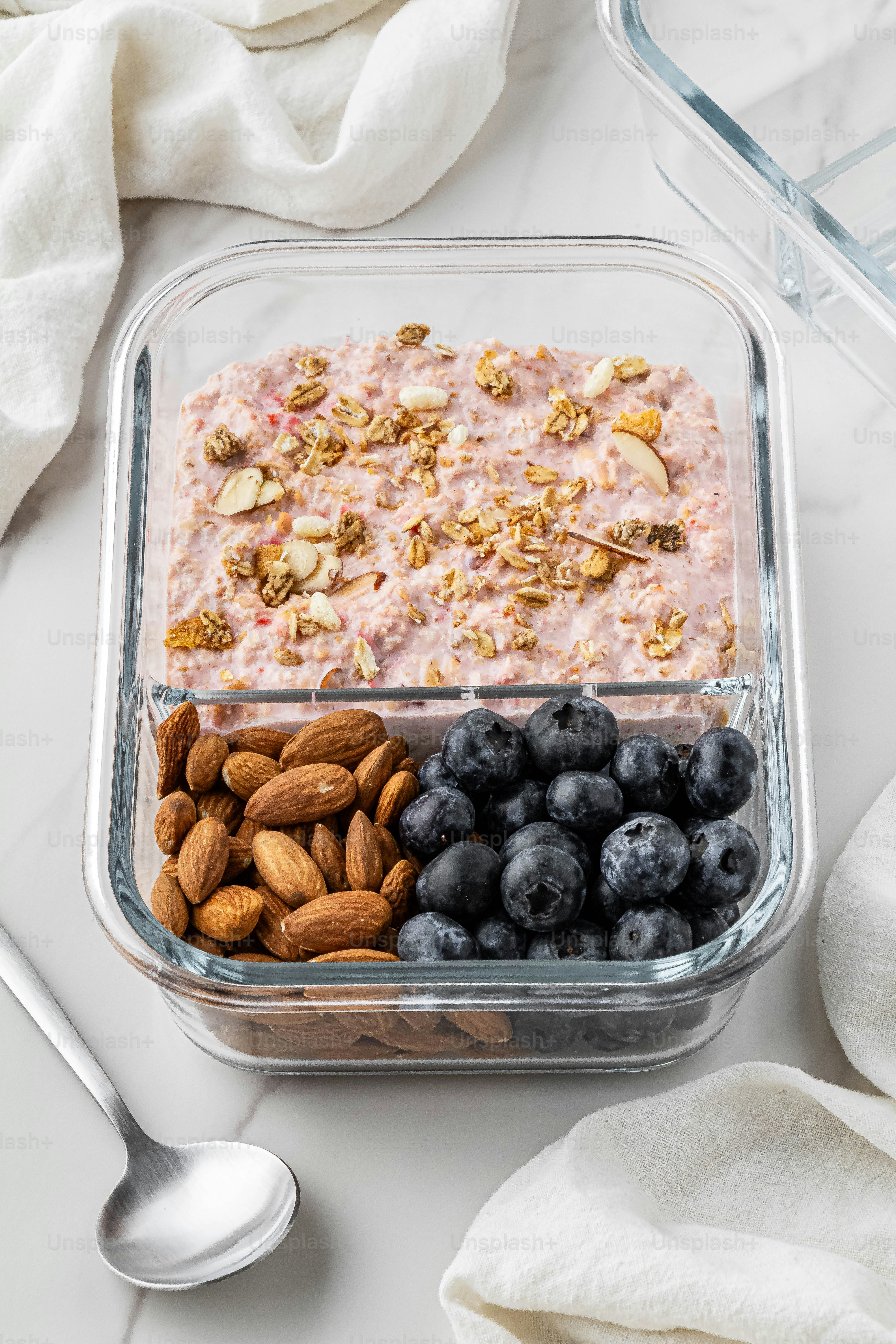 a bowl of cereal, nuts, blueberries, and almonds