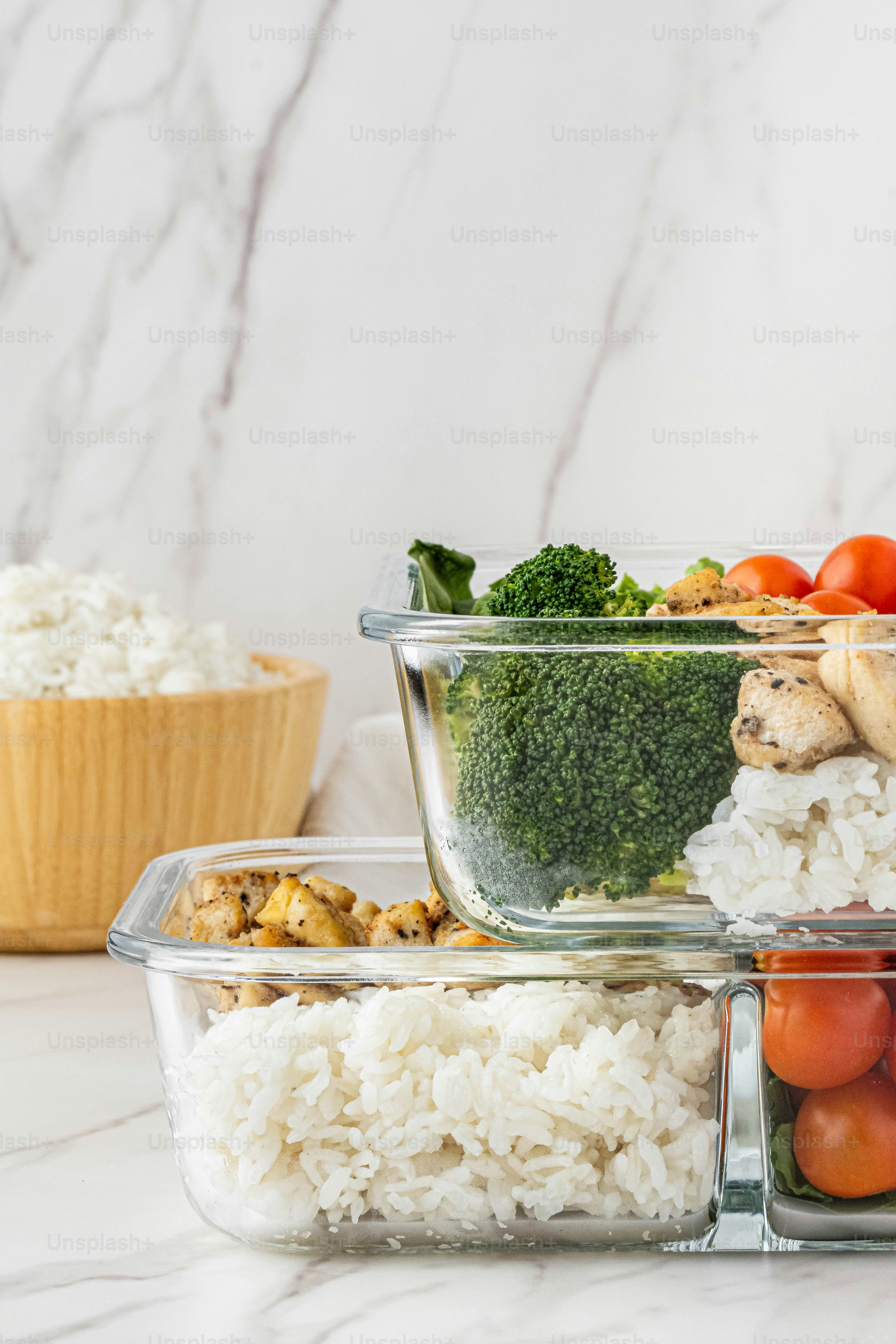a table topped with containers filled with rice and veggies