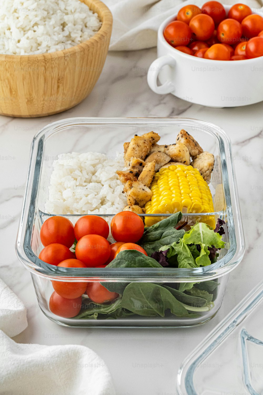 a plastic container filled with vegetables and rice