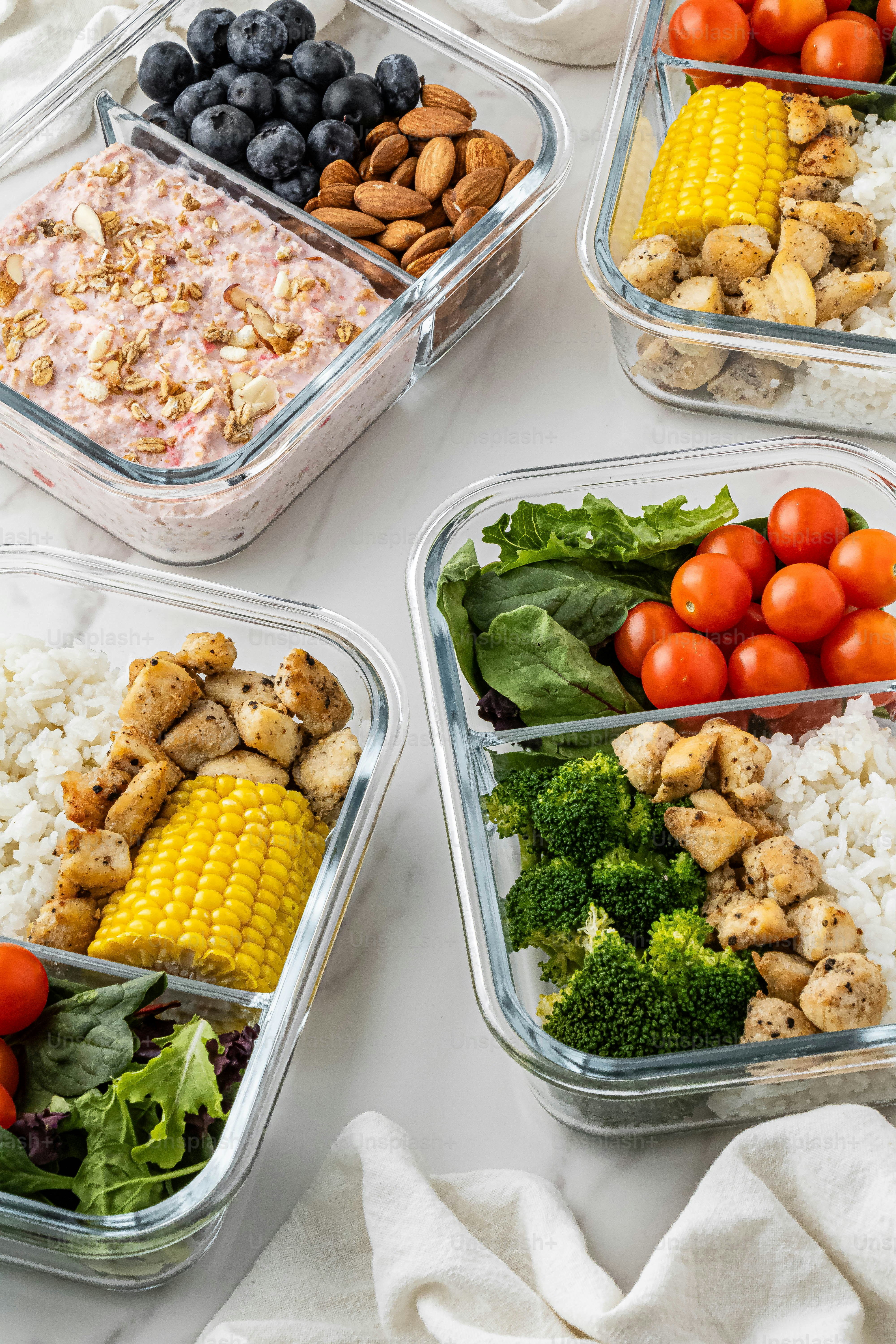 four plastic containers filled with different types of food