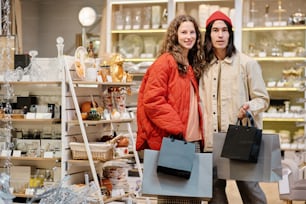 a man and a woman holding shopping bags in a store